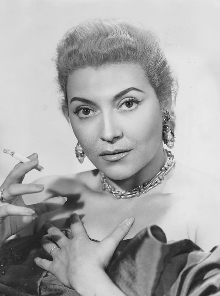 Portrait of Italian singer Nilla Pizzi smoking a cigarette, circa 1955.