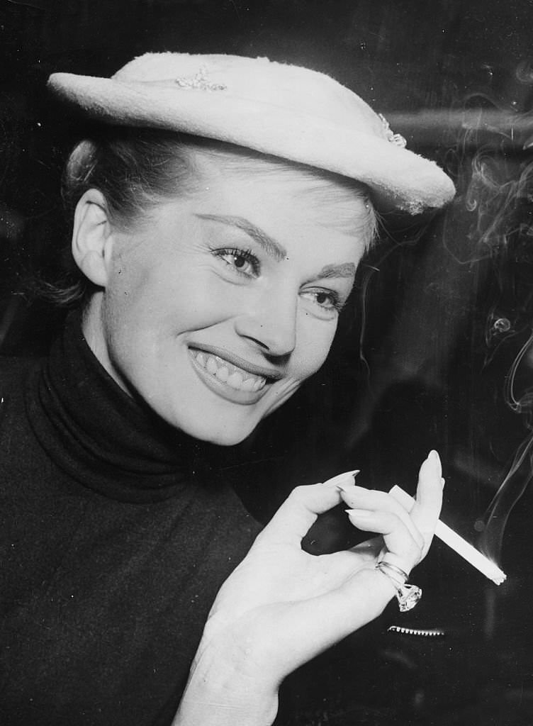 Actress Anita Ekberg smoking a cigarette in Copenhagen, on the way to Malmo, Denmark, 1956.