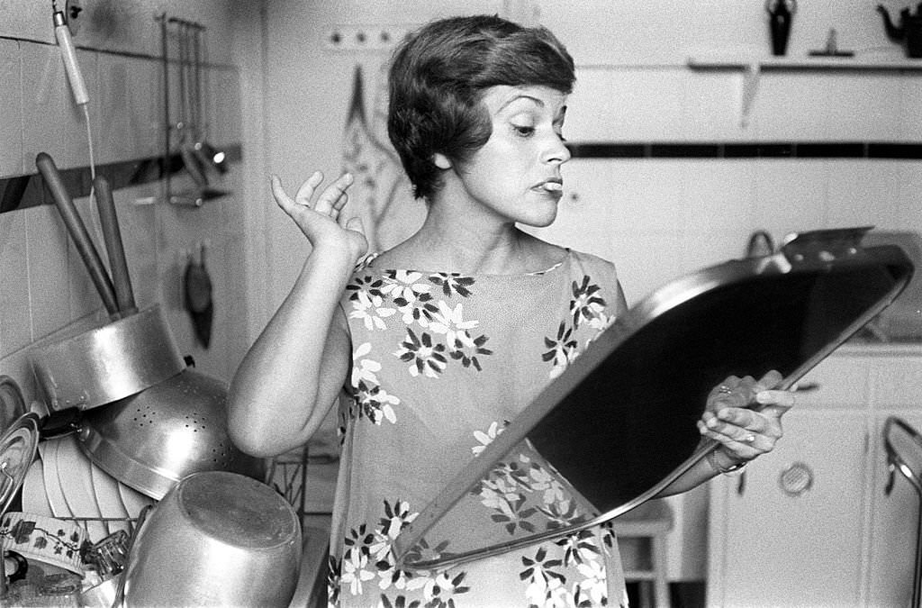 Theatrical actress Franca Valeri looks doubtful at herself in the mirror with a cigarette, Rome, 1958.