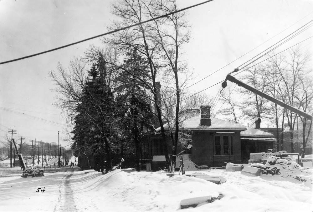 Denver Public Library construction site featuring crane and snow-covered materials, Civic Center houses visible, 1900s