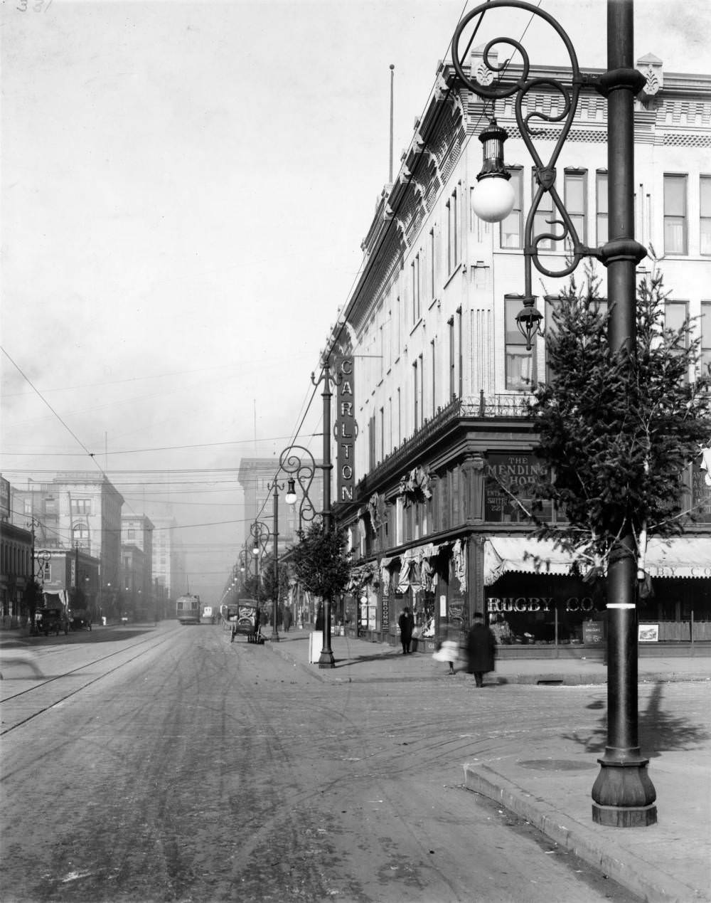 Intersection of 15th and Glenarm Streets in Denver, featuring cars, a streetcar, and Christmas trees, 1900s