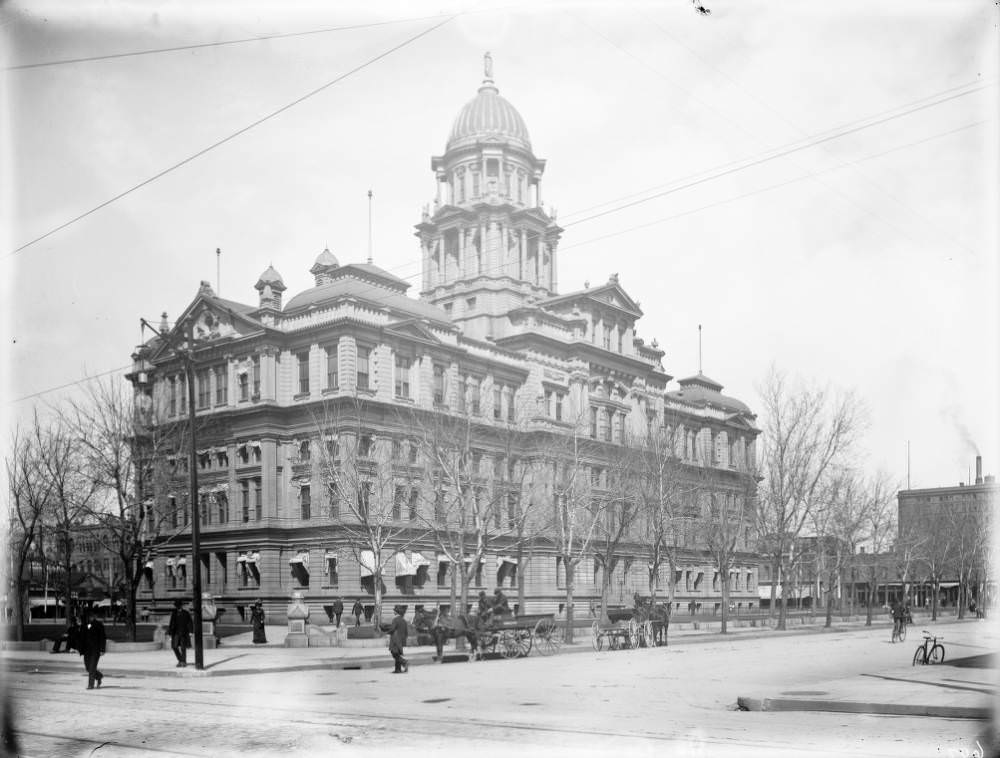 Pedestrians and buggies near the Denver County Courthouse, formerly known as Arapahoe County Courthouse, 1900s