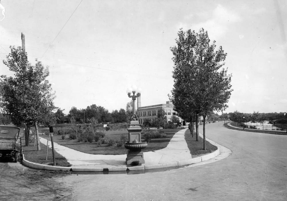 Intersection of Speer Boulevard and Lincoln Avenue, featuring a horse trough and landscaping, Denver, 1900s
