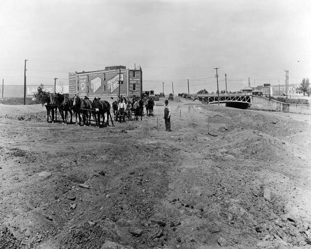 Speer Boulevard under construction, featuring horse and mule-drawn grading equipment, 1900s