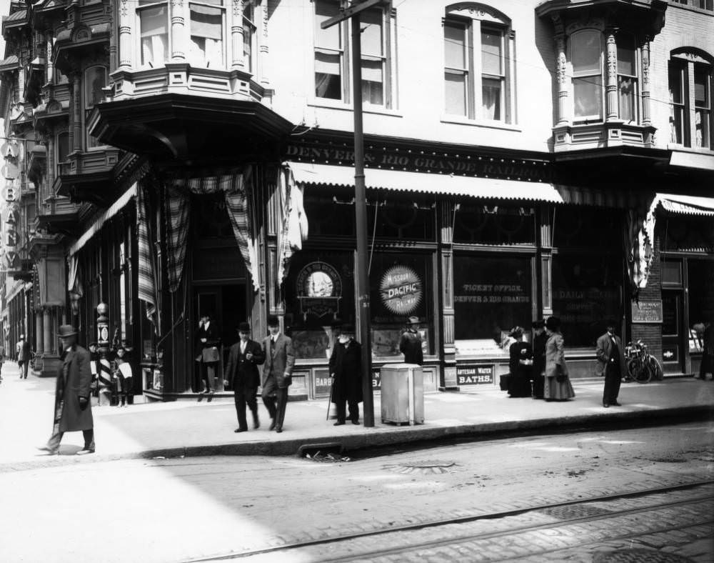 Denver and Rio Grande ticket office in Albany Hotel, featuring pedestrians and newsboys, 1909.