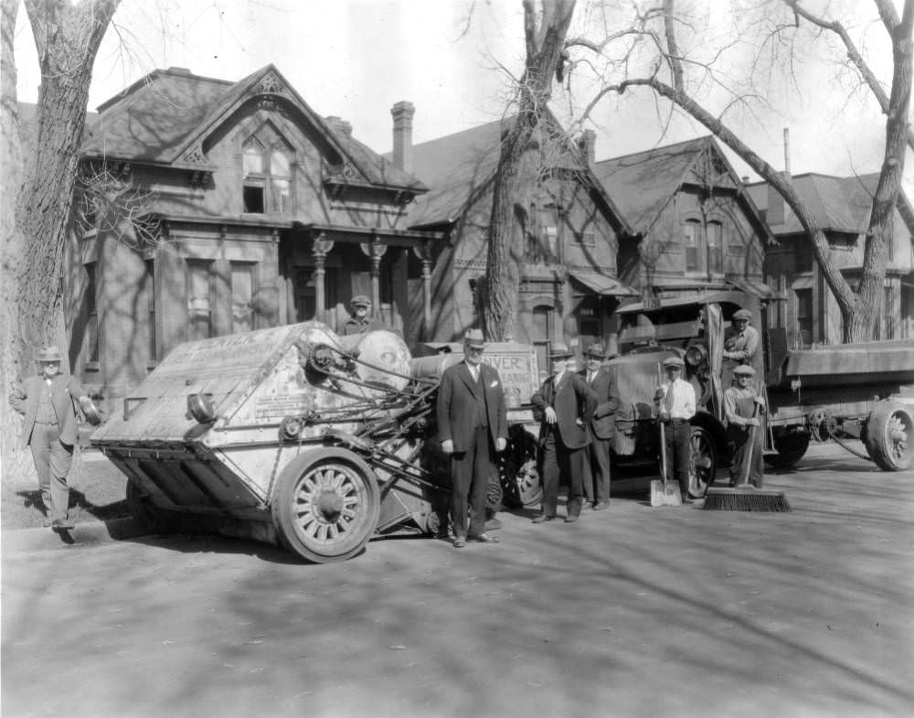 Denver's new motor street cleaner and motor trucks, featuring men posing, 1900s