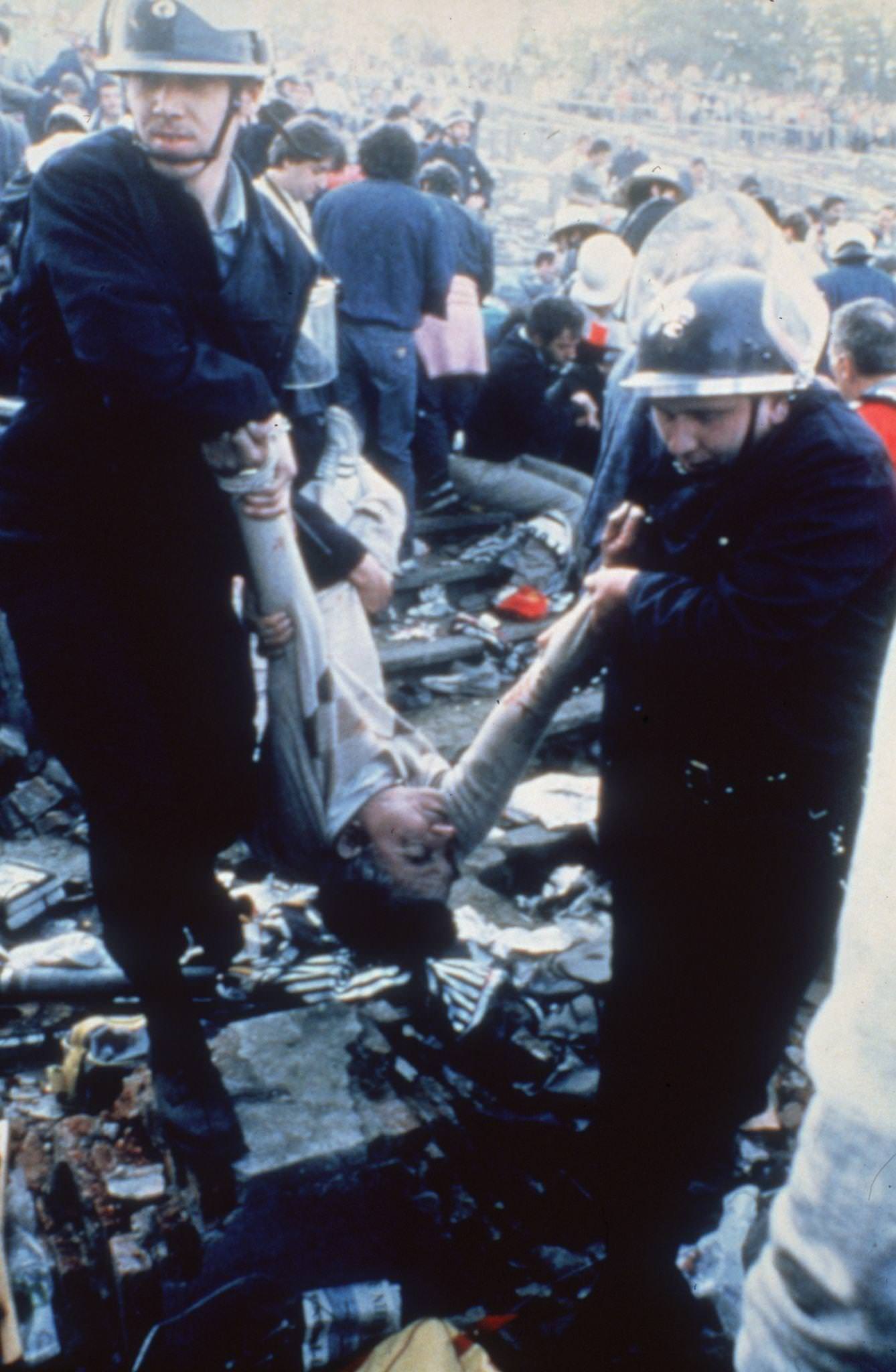 Police carry injured fan after Heysel Stadium violence, European Cup Final, 1985.