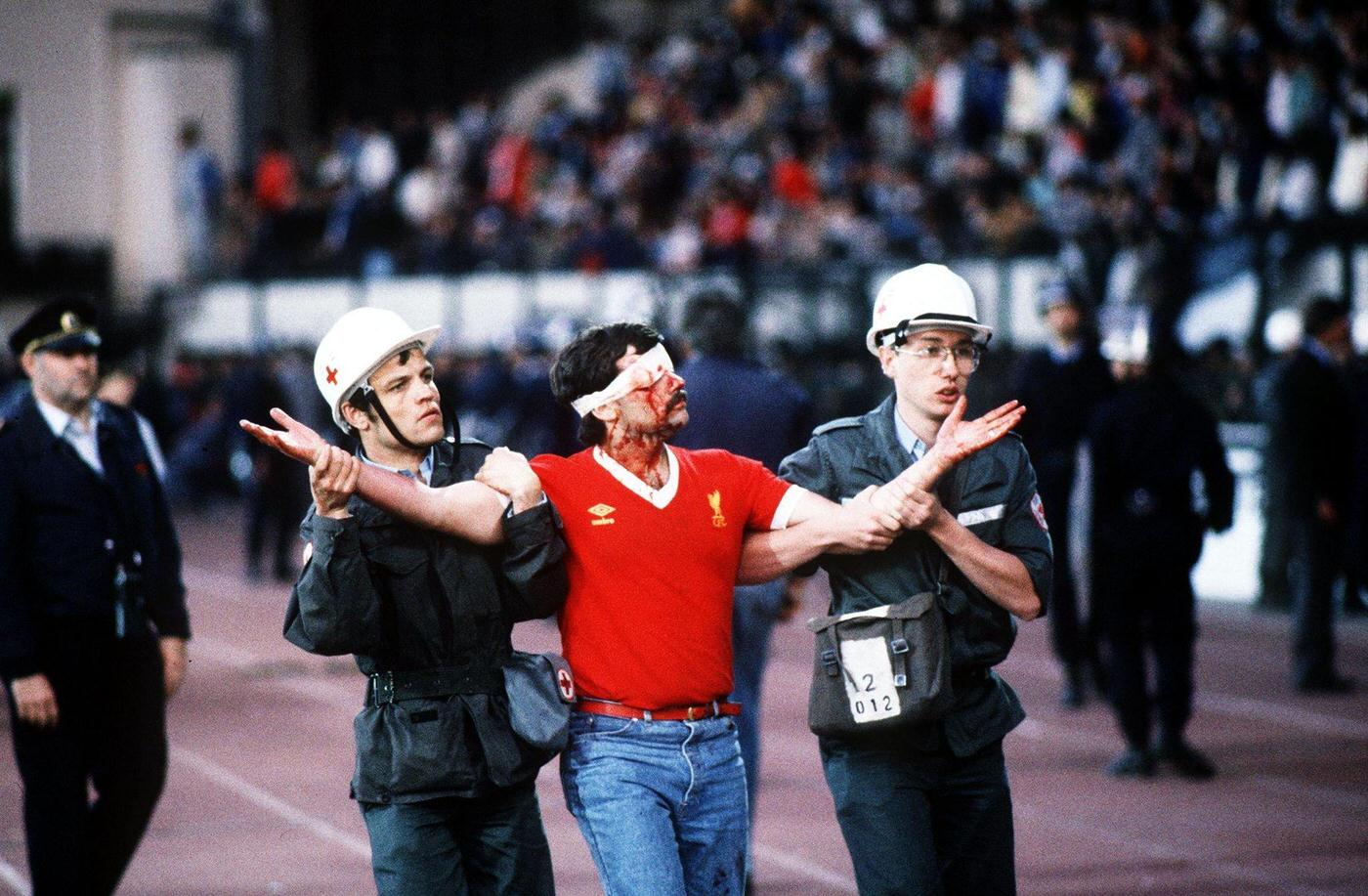 Injured Liverpool fan led away by medical staff at Heysel Stadium, European Cup Final, 1985.