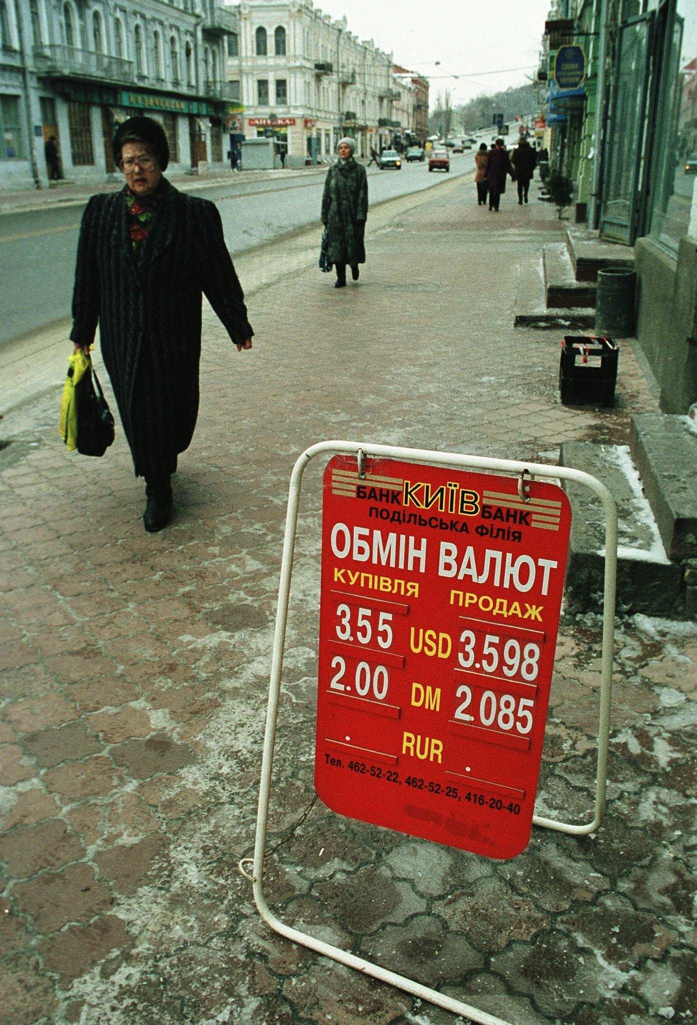 Pedestrians Pass by a Currency Exchange Sign in Downtown Kiev