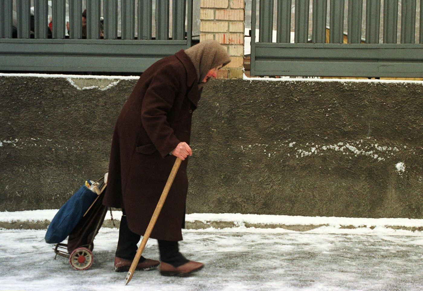 Elderly Woman Carries Groceries on Icy Sidewalk in Kiev