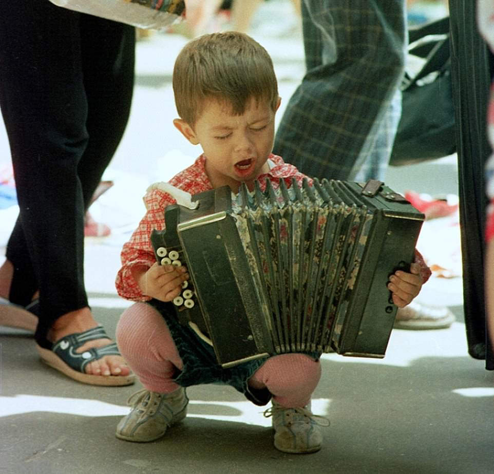 Street Musician: A young boy impresses with his accordion skills on the streets of Kyiv, 1998.