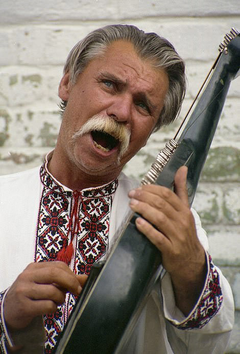 Sounds of Kyiv: Market man holds dried fish, part of Kyiv's vibrant scene, 1999.