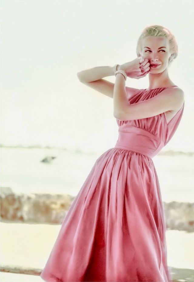 Sunny Harnett wears a rose-pink summer dress with a molded empire midriff and drawstring bodice, 1954.
