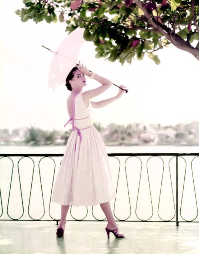 Theo Graham in a pink polka-dot dress tied at the back with thin straps, in Puerto Rico, 1954.