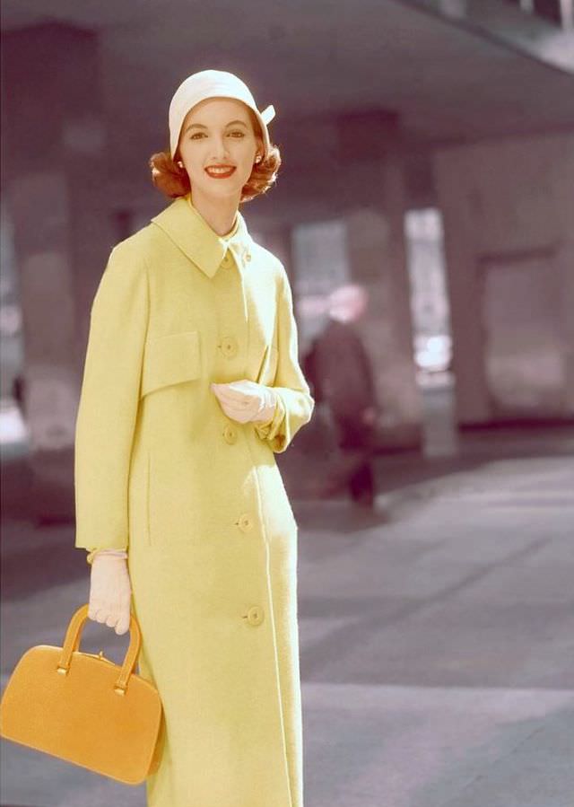 Joan Romano wears a yellow wool coat by Swansdown and accessories by multiple designers, 1955.