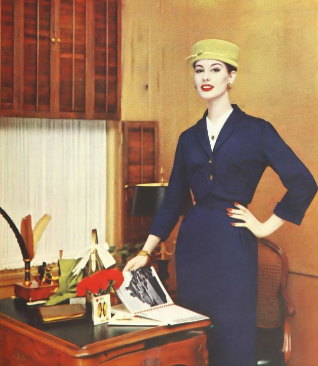 Nancy Berg in a wool jersey suit with brass buttons and white pique accents, 1957.