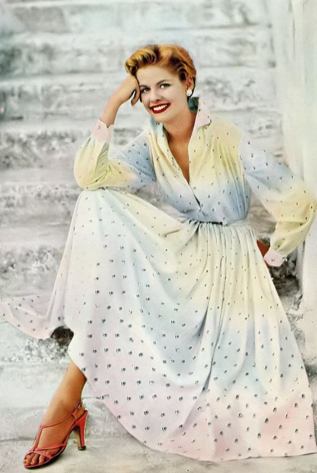 Model dons a full-skirted shirtwaist dress in ombre cotton embroidered with pearls by Emilio Pucci, 1954.