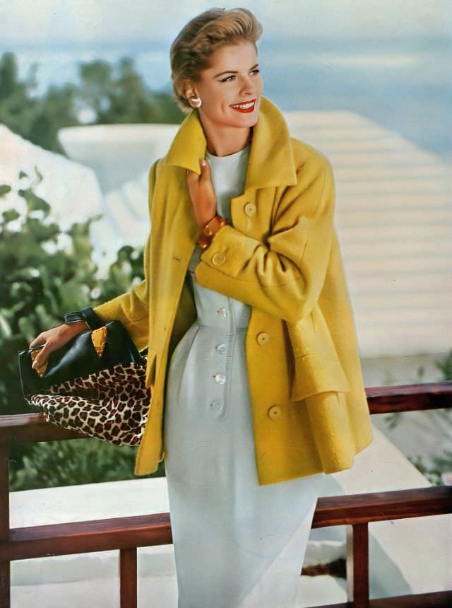 Model wears a lemon-yellow tweed coat by Lo Balbo over a white raw-silk sheath by Branell, 1954.