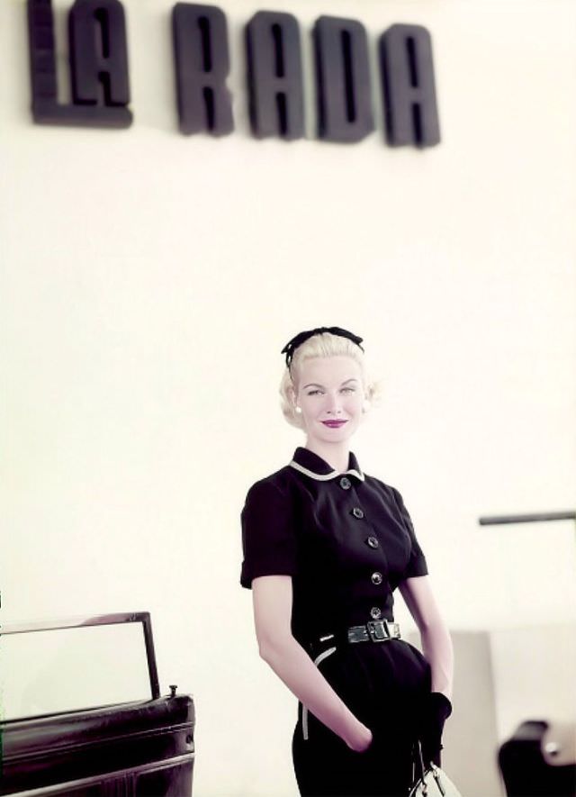 Sunny Harnett sports a black linen dress with gingham-trimmed collar and pockets, belted in black patent leather, in Puerto Rico, 1954.