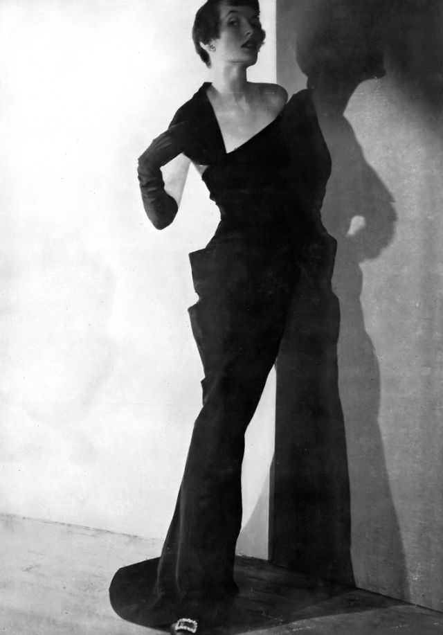 Maxime de la Falaise in a slim black grosgrain evening gown by Paquin, 1949.