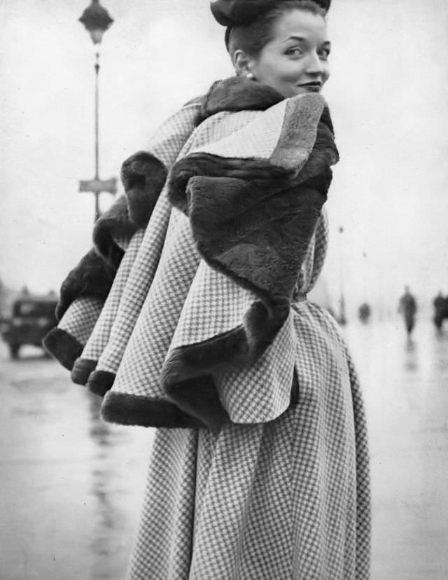 Maxime de la Falaise in a checked wool dress with patent leather belt and detachable nutria-lined cape by Jacques Fath, 1948.