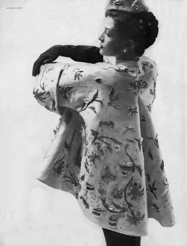 Maxime de la Falaise wearing a white linen evening jacket intricately embroidered in silver and steel by Christian Dior, 1948.
