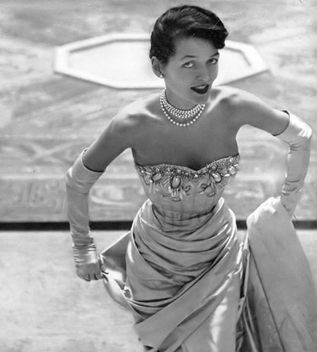 Maxime de la Falaise in nacre satin evening dress with pearls and crystals by Jacques Fath, 1948.
