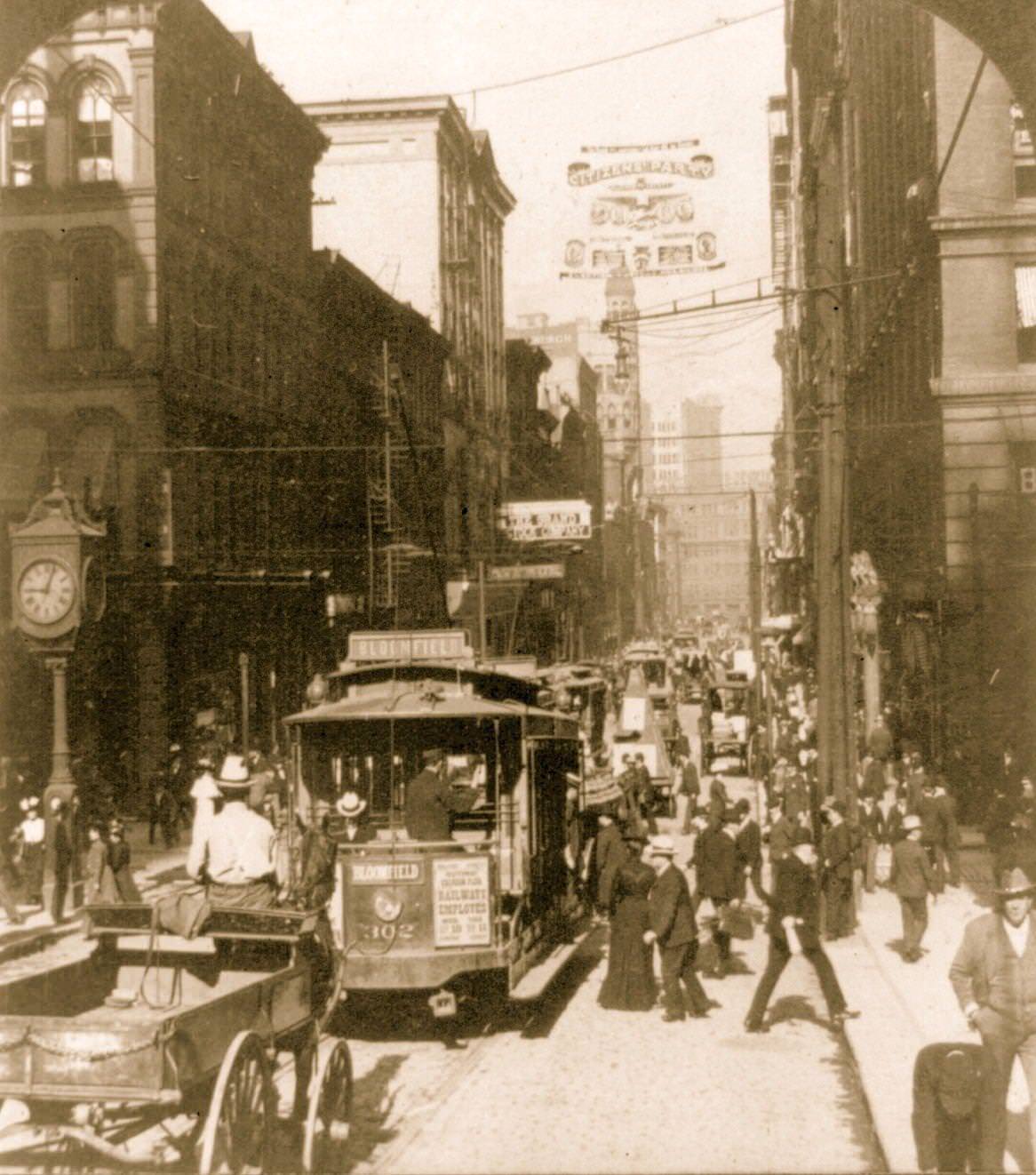 Bustling 5th Avenue west from Smithfield in Pittsburgh, featuring trolley cars and pedestrians, 1903.
