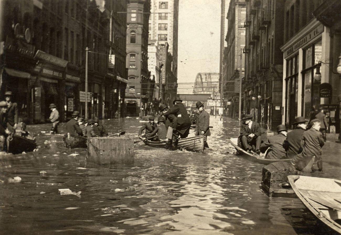 Men and boys navigating floodwaters at the intersection of Sixth & Liberty Streets in Pittsburgh, 1907.