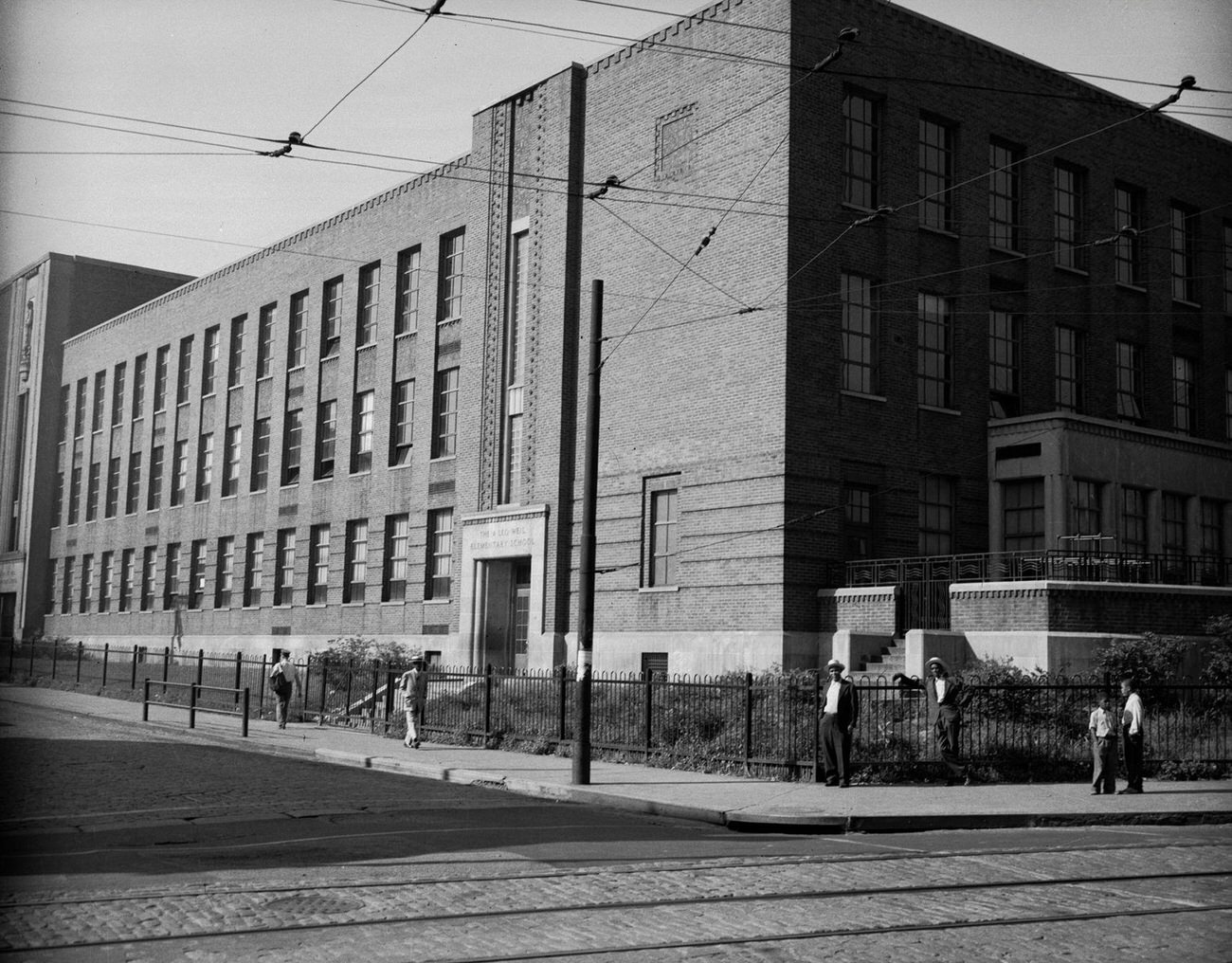 A Leo Weil Elementary School Exterior with Four People, 1946