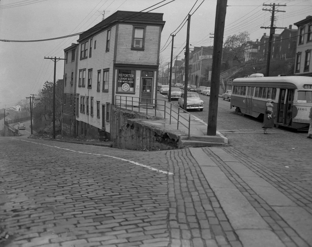 East Warrington Avenue and Brosville Street featuring a reporter's office with sign "Leave Ads and News Here," 1956