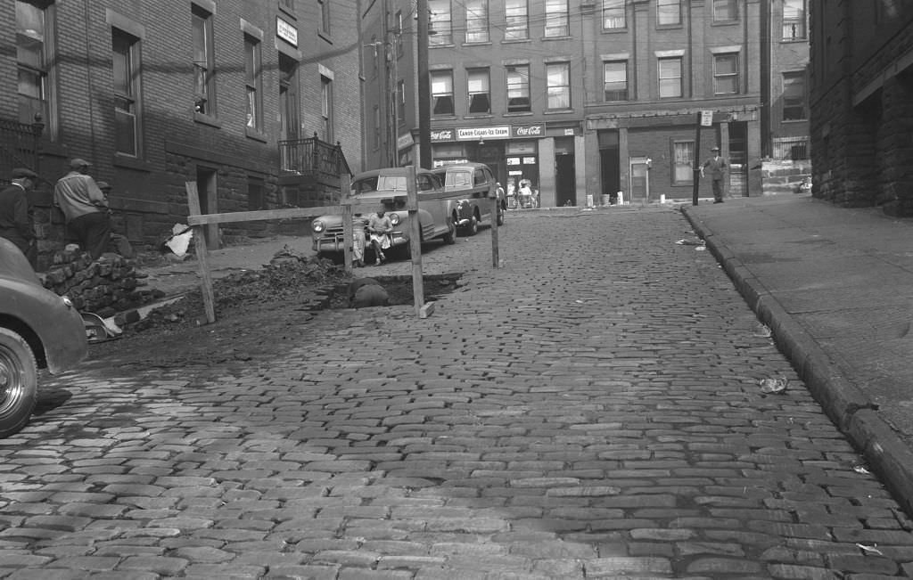 Stevenson Street with workers repairing the road and children watching, 1950.