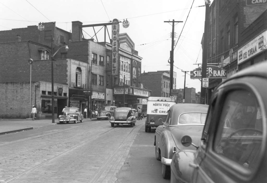 Centre Avenue at Dinwiddie Street featuring Roosevelt Theatre and neighborhood businesses, 1951.