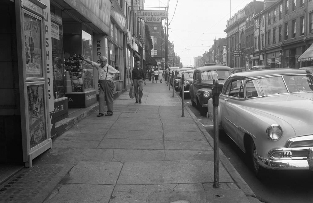 Man leaning on Domestic Appliance Co.'s window next to Acadia Theater on East Ohio Street, 1951.