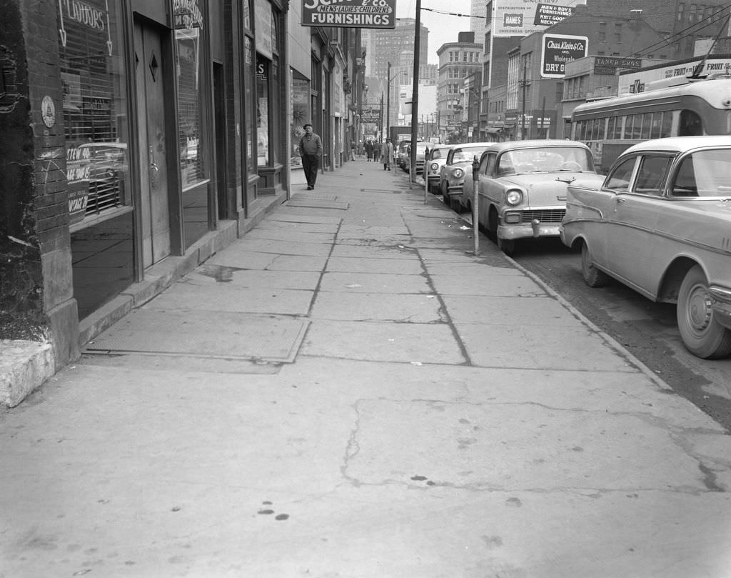 Fifth Avenue downtown, features local businesses and trolley cars, 1960.