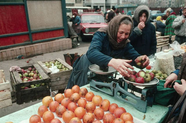 Woman weighing apples, Ukraine, 1991
