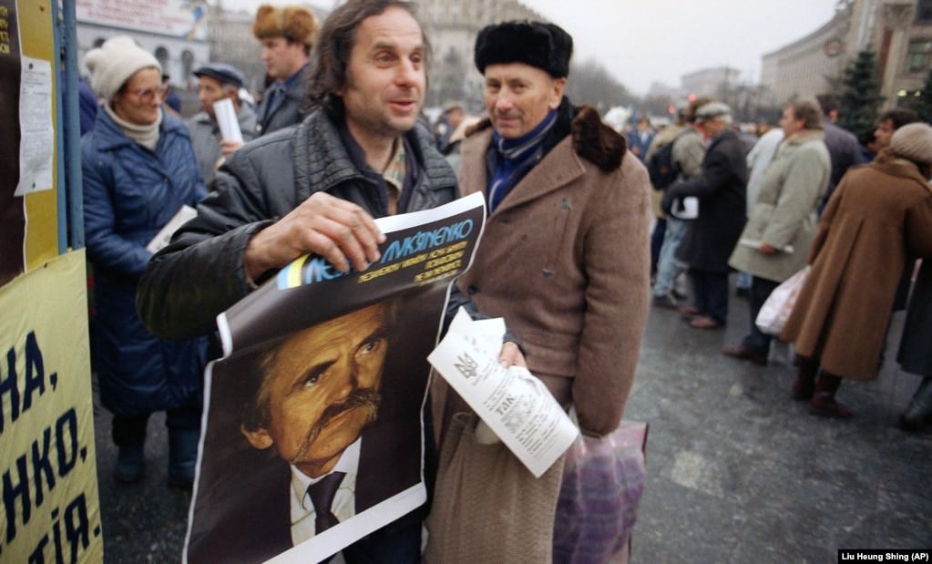 A supporter carries a campaign poster for former dissident Lukyanenko, now a presidential candidate, in Kyiv.