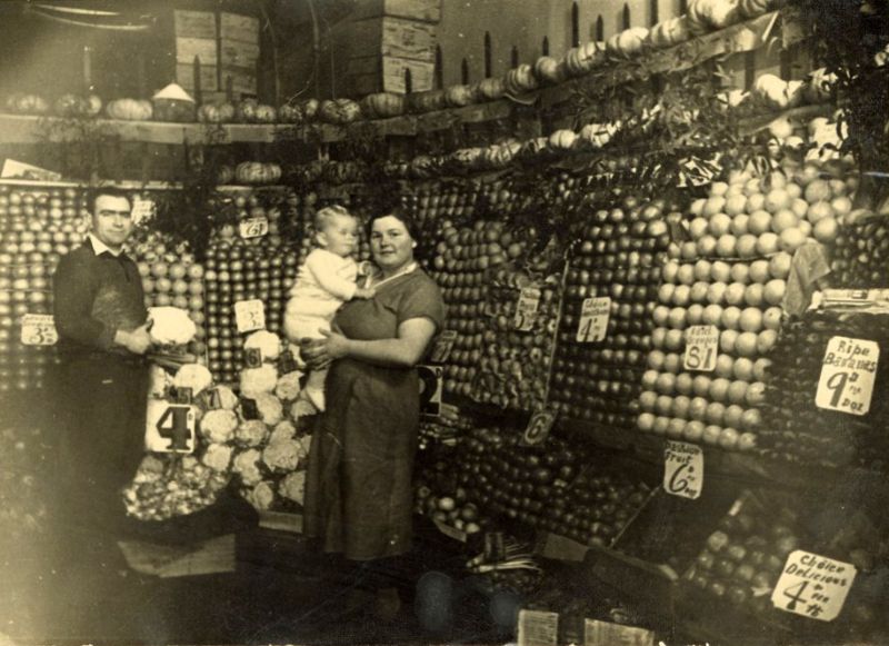 Man, woman, and child in a fruit and vegetable shop