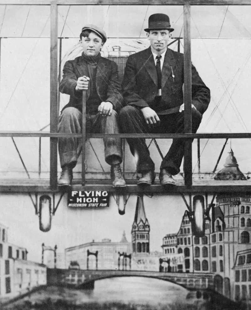 Father and son posing in a plane at the Wisconsin State Fair, 1900s.