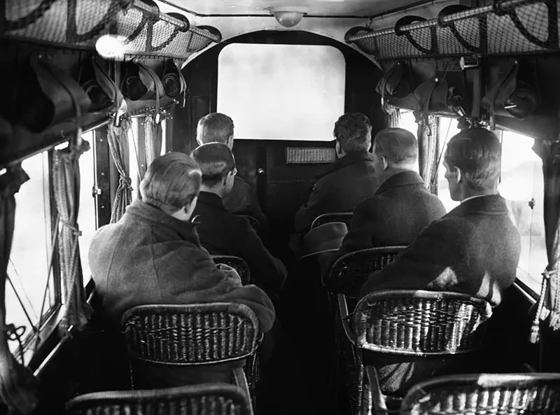Passengers watching the first ever in-flight movie.