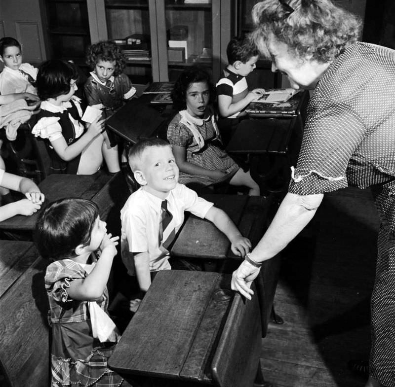 Children getting to know their new teacher, circa 1950