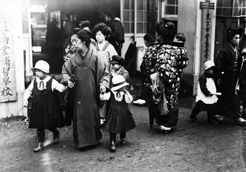 Parents and their children are seen outside a school in Tokyo in the early 20th century