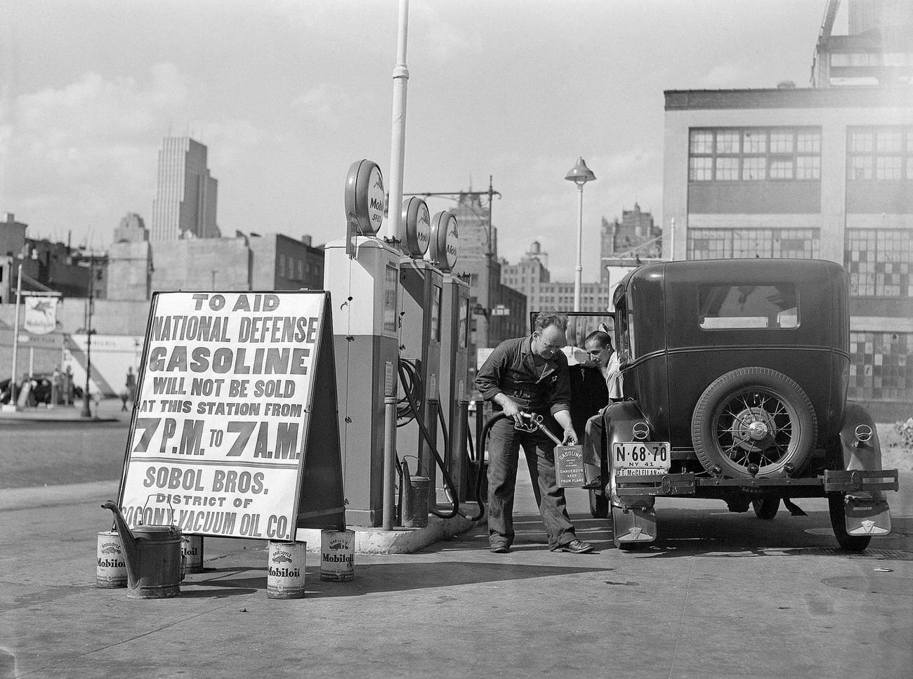Gas attendant fills spare cans at New York City gas station complying with Governmental Conservation Edict, 1941.