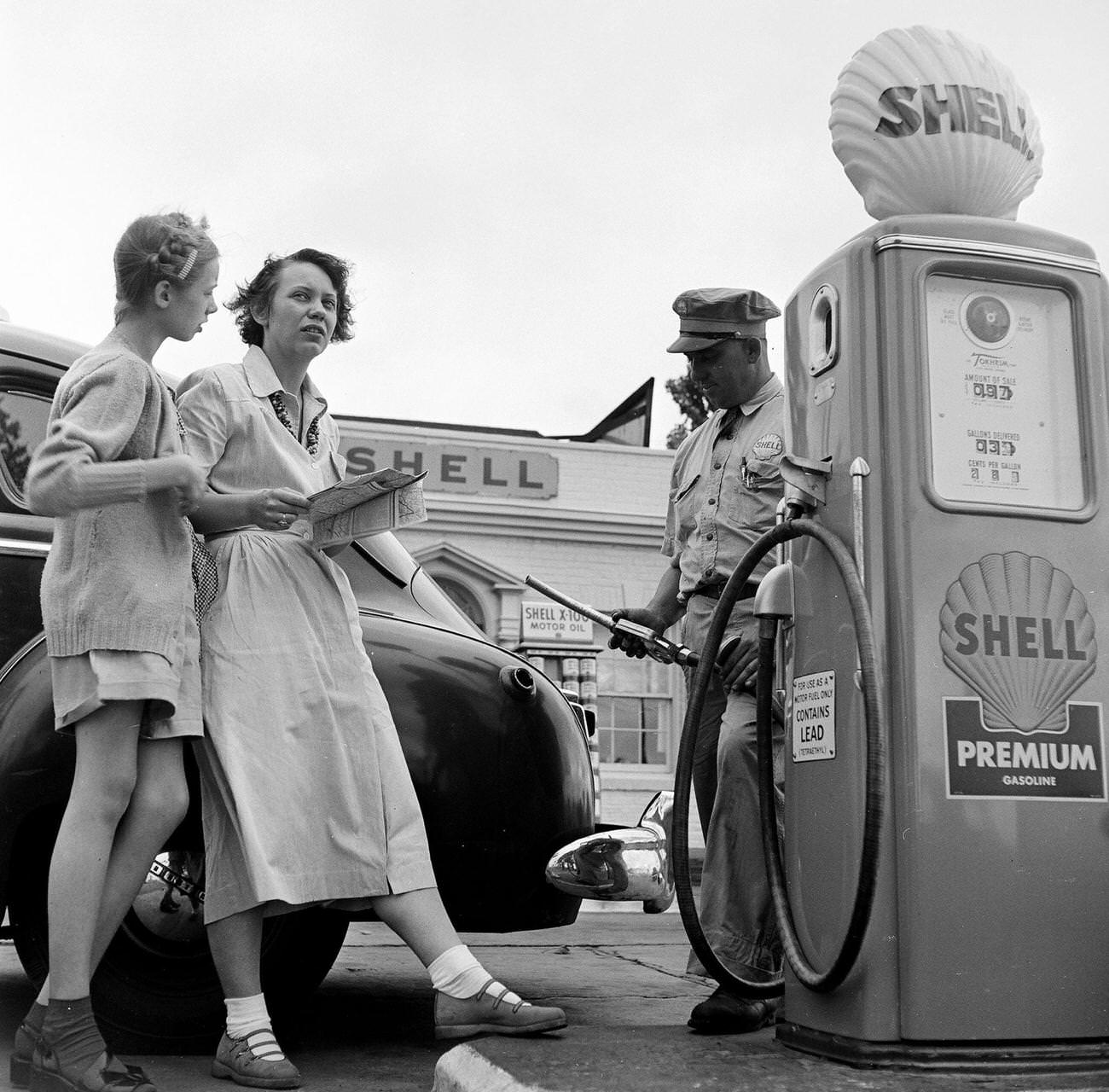 Mother and daughter consult map at Shell station in Virginia, 1949.
