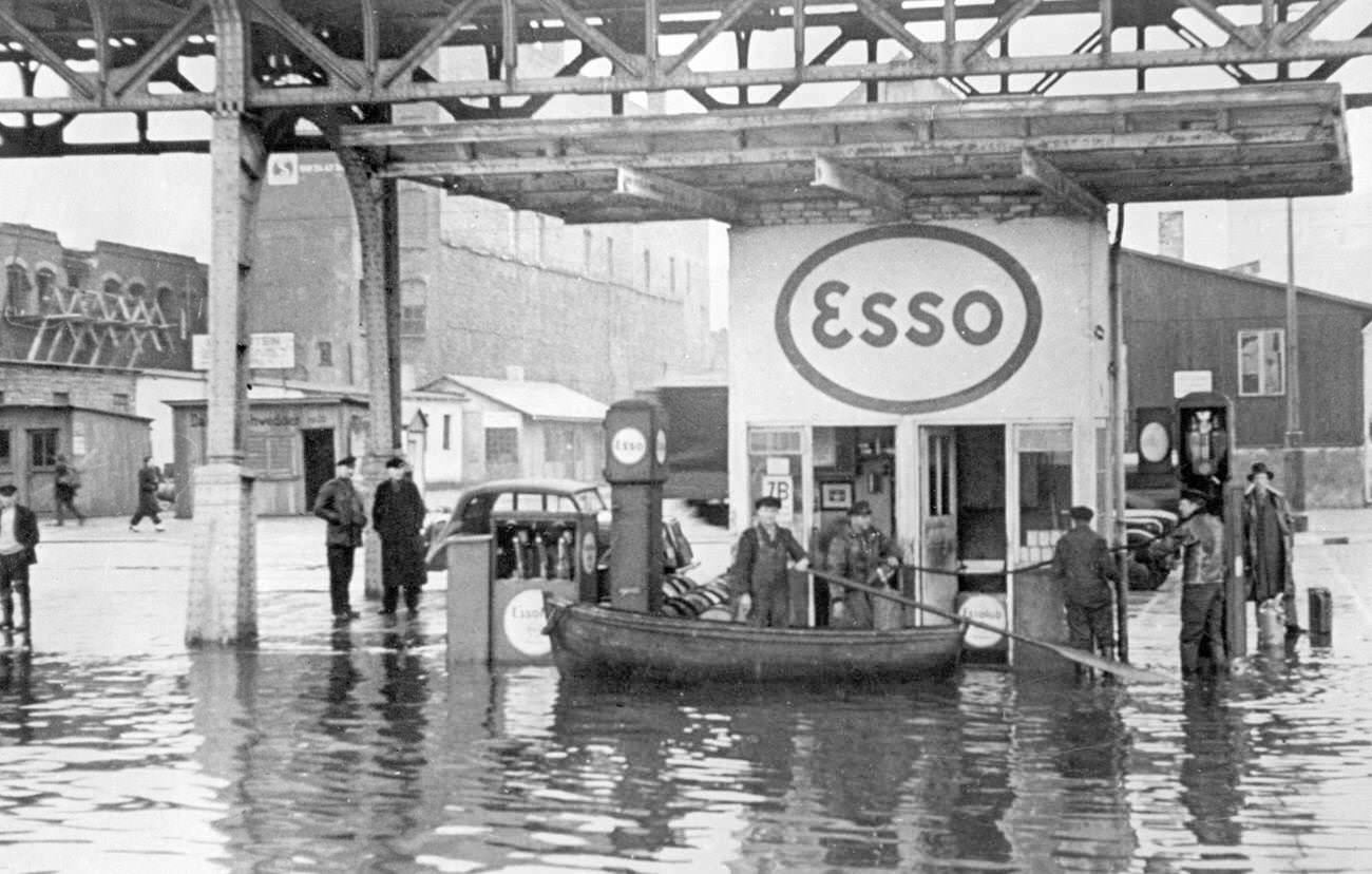 Rowboat delivers gasoline to customers during flood in Hamburg, 1949.