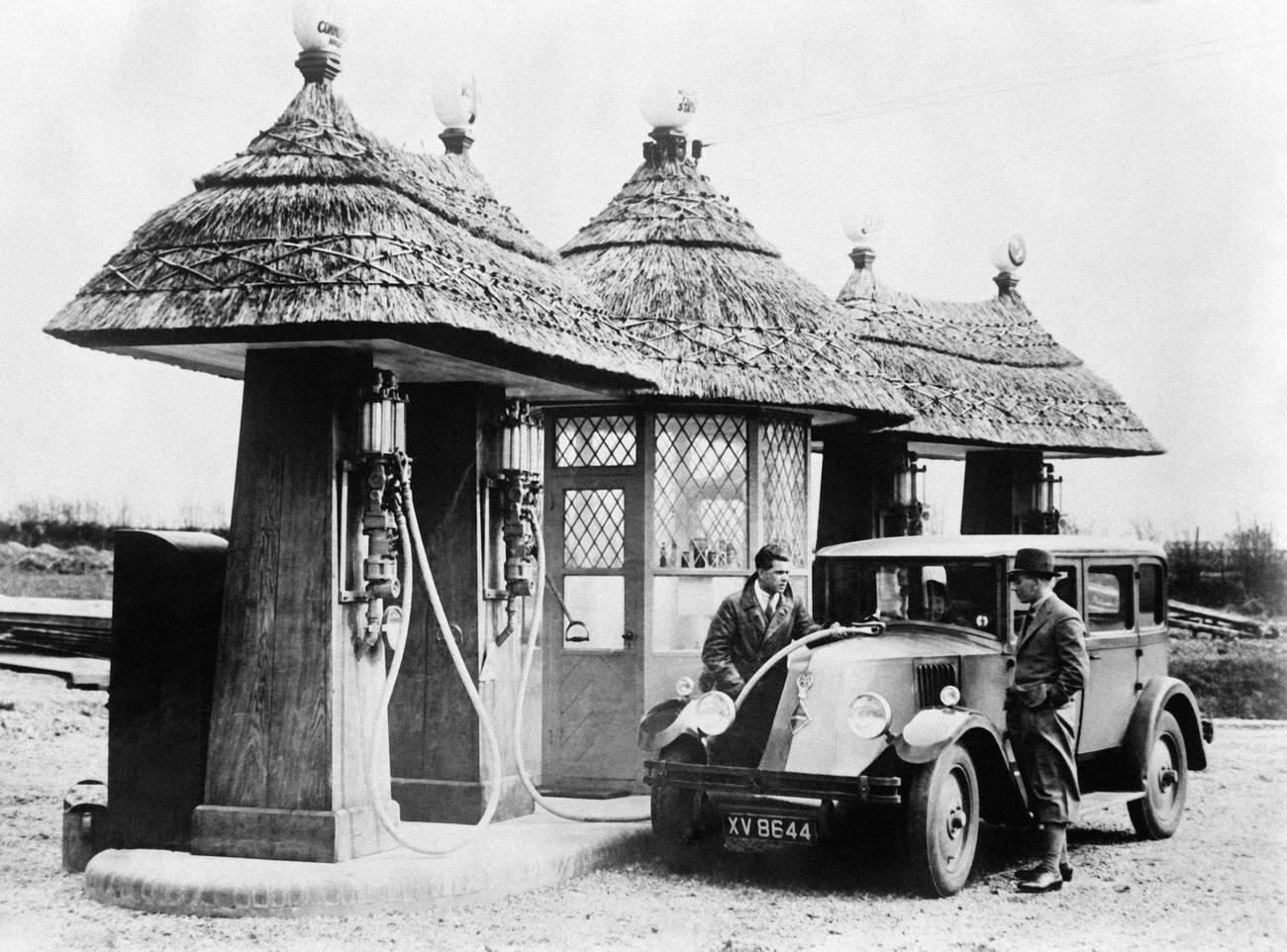 New thatched-roof gas station in England, United Kingdom, 1930.