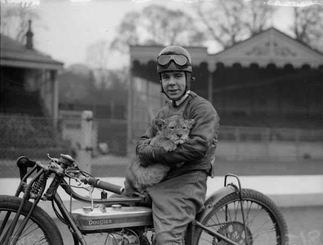 Triss Sharp, a motorcyclist, with his lion cub mascot at Crystal Palace, London, 1930.