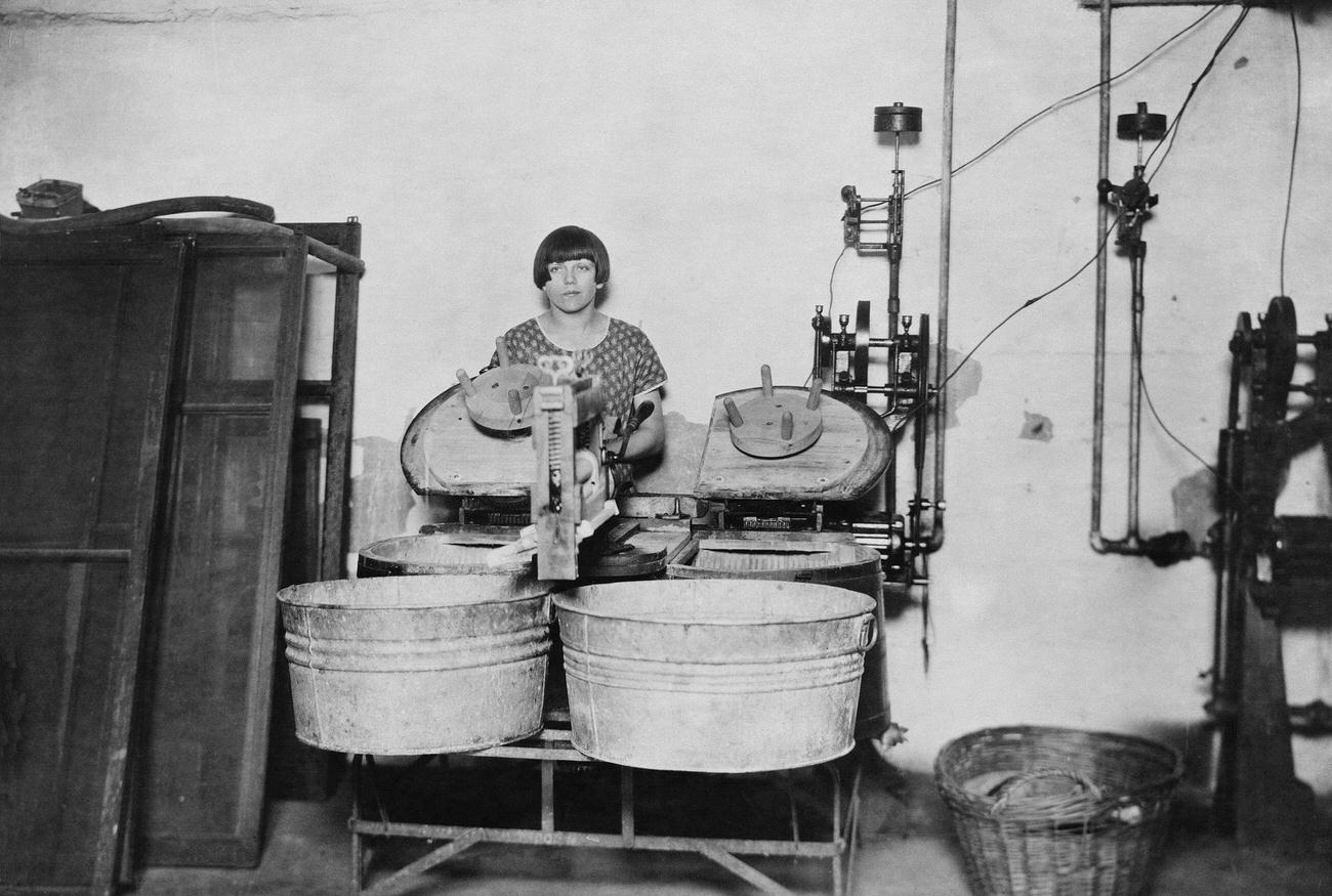 Bessie Flamoe using an electric washing machine.