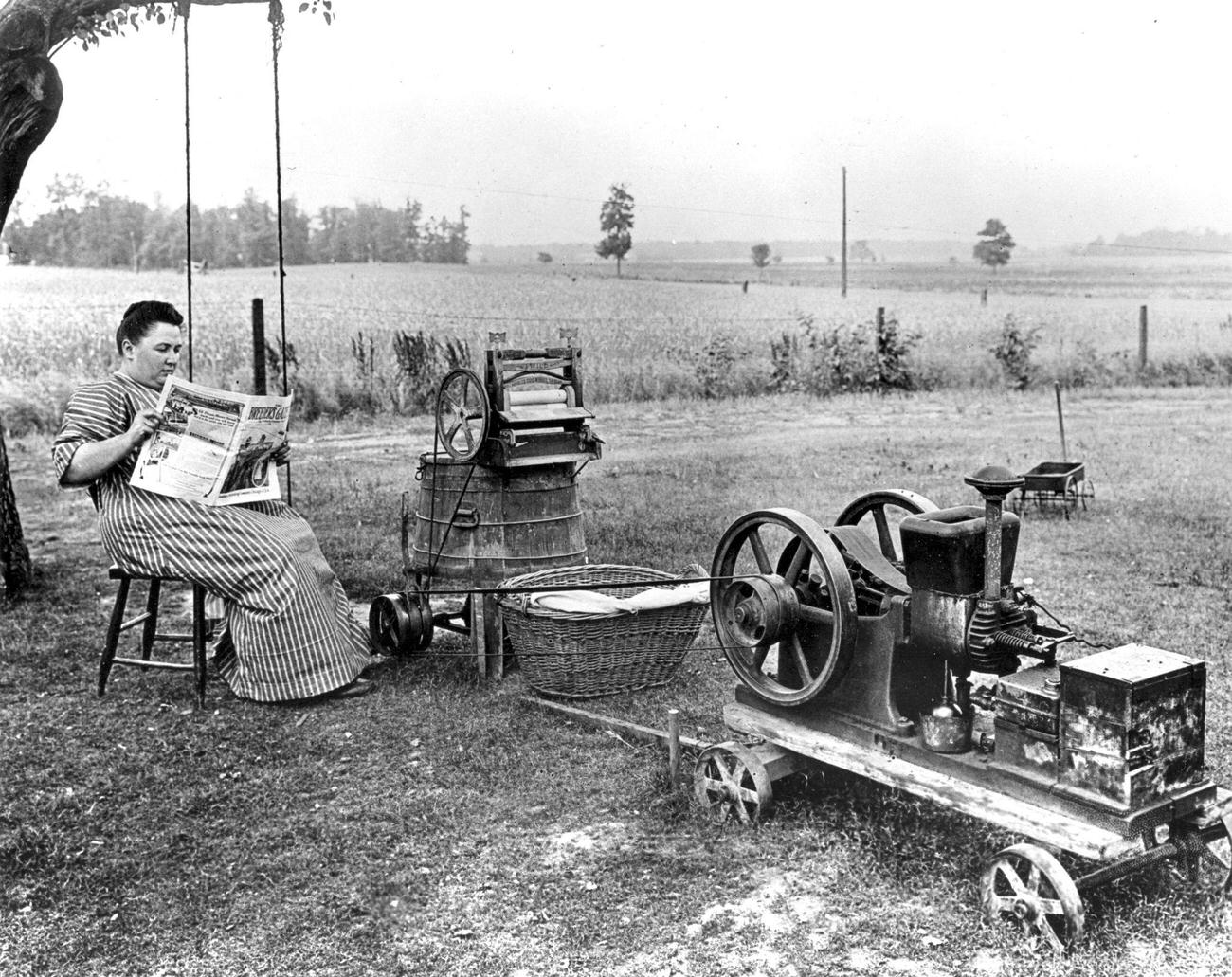 Woman reading beside a gas-powered washing machine, Midwest, 1914.