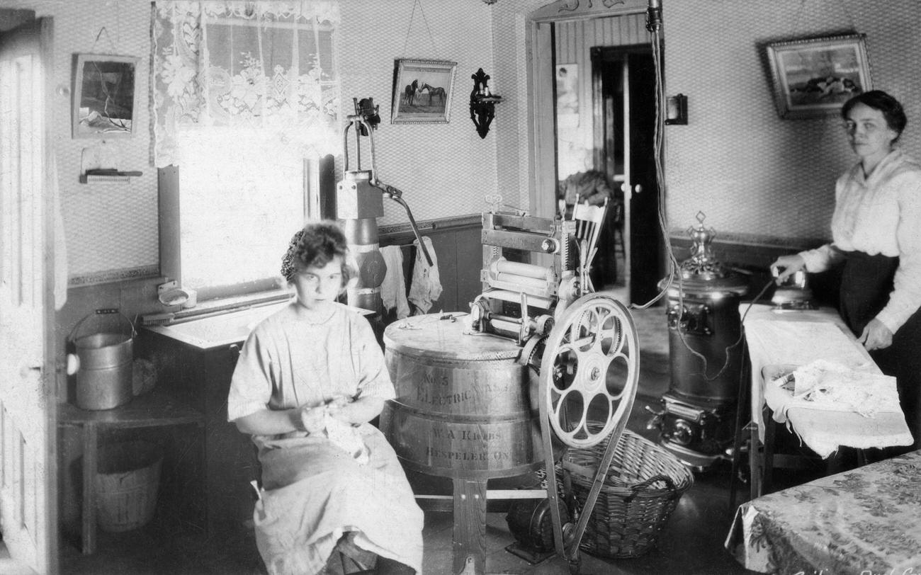 Housewife and daughter in kitchen with washing machine, Ontario County, Ontario, Canada, 1920.